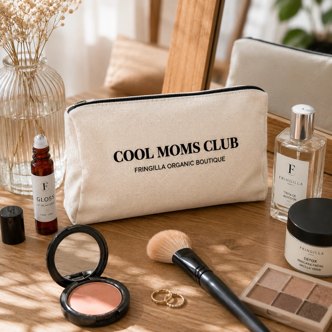Cosmetiquera Cool Moms Club Fringilla sobre tocador con maquillaje y productos de belleza para uso diario